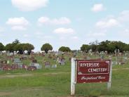Riverside Cemetery Sign with gravestones in the background