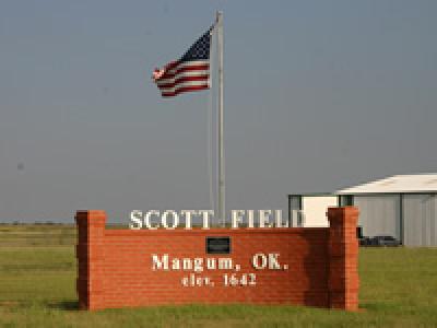 Scott Field Brick Wall Sign with American Flag on a post behind it