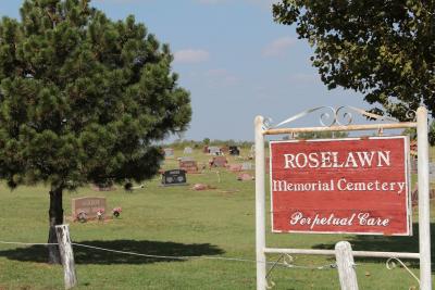 Roselawn Memorial Cemetery Sign with gravestones in the background