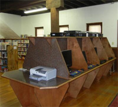 4 computer stations side by side with wooden dividers